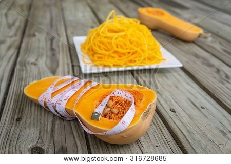 Measuring Tape Wrapped Around Butternut Squash Cut In Half With Low Carb Noodles