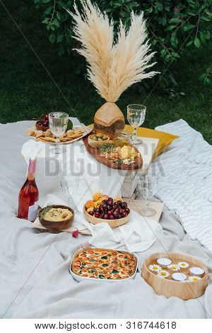 Appetizers Table For Picnic. Cherries, Apricots, Avocado, Olives, Cheese, Nuts, Hummus, Pizza, Dried