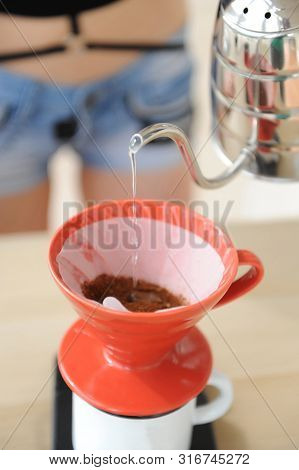 Girl Barista Brews Coffee Drip Method. Pouring Water From Gooseneck Kettle Into Red Hario V60 Funnel