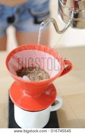 Girl Barista Brews Coffee Drip Method. Pouring Water From Gooseneck Kettle Into Red Hario V60 Funnel