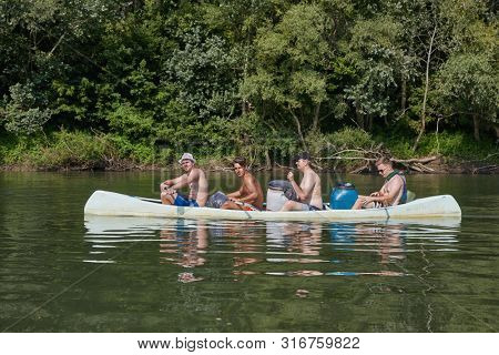 TIVADAR, HUNGARY - JULY 21, 2017: Group of young people canoeing on the river Tisza with camping ewuiment. The second larges river of Hungary, popular for water activities.