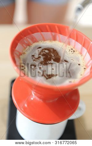 Brewing Coffee Drip Method. Pouring Water From Gooseneck Kettle Into Red Hario V60 Funnel.