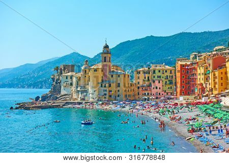 Camogli, Genoa, Italy - July 1, 2019:  Beach and waterfront in Camogli town near Genoa on sunny summer day, Liguria