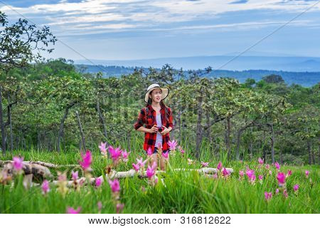 Woman Traveler With Backpack Enjoying At Krachiew Flower Field, Thailand. Travel Concept.