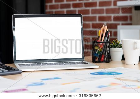 Mockup Laptop Computer Screen With Business Chart Market,caculator,coffee Cup,pencil Box On Desk At 