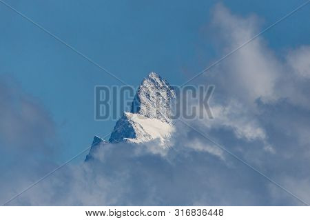 Summit Of Swiss Finsteraarhorn Mountain In Clouds, Blue Sky