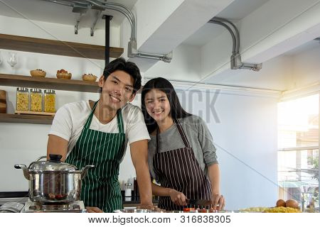 Portrait Of Cute Happy Couple In Aporn In Selfie Action Posting With Mobile Phone Decorated With Sal