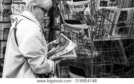 Strasbourg, France - May 25, 2019: Side View Of Senior Woman Reading German Taz Newspaper At Press K