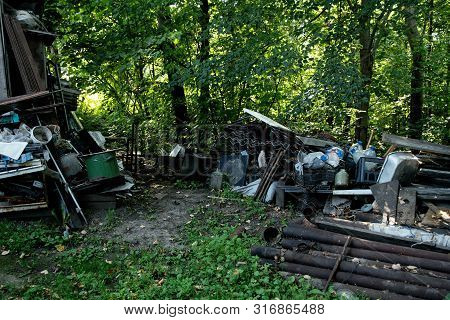 Inefficient waste from metal pipes, wooden boards, plastic bottles dumped in the forest
