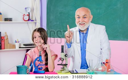 Experienced Pedagogue. Chemistry And Biology. Little Girl With Man Tutor Study Science. Teacher Help