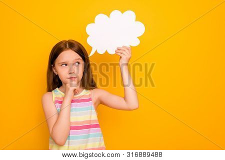 Portrait Of Minded Child Holding Paper Card Bubble Touching Chin Planning Isolated Over Yellow Backg