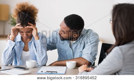 Bankruptcy And Investment Mistakes. African American Husband Comforting His Crying Wife On Meeting W