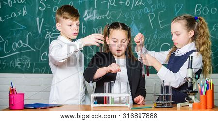 Little Kids Learning Chemistry In School Laboratory. Students Doing Biology Experiments With Microsc