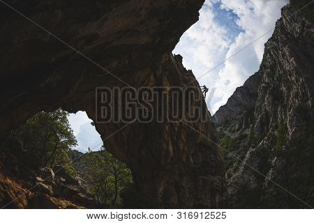 Rock Climbing And Mountaineering In The Paklenica National Park. A Woman Overcomes A Challenging Cli