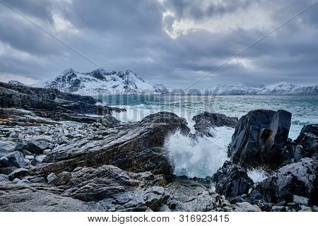Waves of Norwegian sea crushing at rocky coast in fjord. Vikten, Lofoten islands, Norway