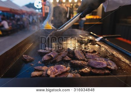 Roasted Duck On A Grill Outdoor. Slices Of Appetizing Fresh Meat During Frying. Evening Meal.