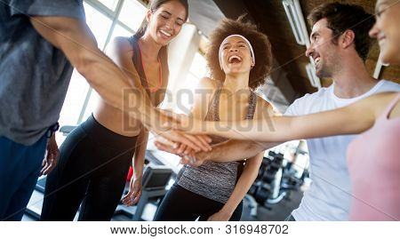 Happy Gorup Of Healthy People Training In Gym