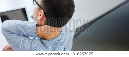 Businessman Office Worker Holding Sore Neck Pain From Desk Working And Sitting All Day Using Laptop 