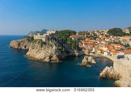 View Of Dubrovnik And It's City Wall From The Adriatic Sea With Fort Lovrijenac
