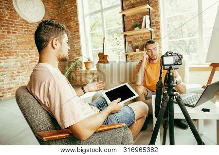 Two Young Caucasian Male Bloggers In Casual Clothes With Professional Equipment Or Camera Recording 