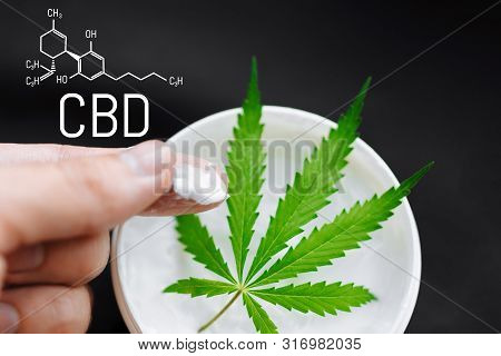 Cannabis Cbd Cream. Top View Of Jar With Cbd Hemp Salve With Cannabis Leaf On Black Background. Mari