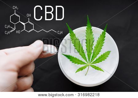 Cannabis Cbd Cream. Top View Of Jar With Cbd Hemp Salve With Cannabis Leaf On Black Background. Mari