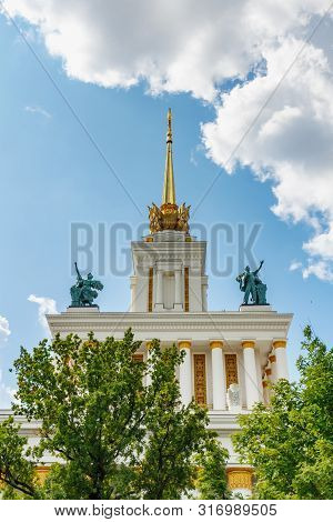Moscow, Russia - July 22, 2019: Roof Of Pavilion Ussr On Vdnh In Moscow Against Blue Sky And Green T