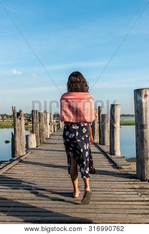 Vertical Picture Of Brunette Woman Walking At Wooden U Bein Bridge, Which Is A Touristic Attraction 