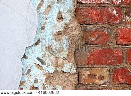An Old Damaged Brick Wall Partially Covered With Two Layers Of Plasterwork