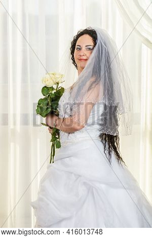 A Jewish Bride Stands In The Hall Before The Chuppa Ceremony With A Bouquet Of White Roses In Her Ha