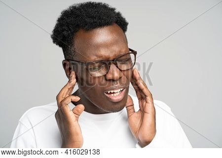 Sick African American Millennial Man Suffering From Tinnitus, Throbbing Earache, Tired Of Noise. Irr