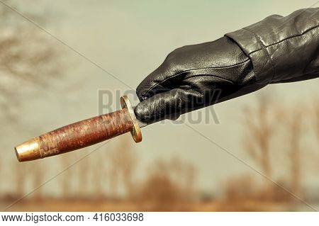 Detail Of Throwing Knife Holding In Hand Dressed In Leather Glove