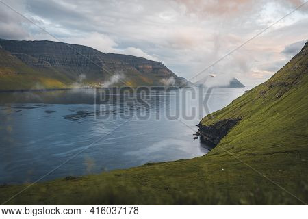 Faroe Islands Kalsoy In Sunset Light Durig Twilight With Pink Sky And Cliffs.