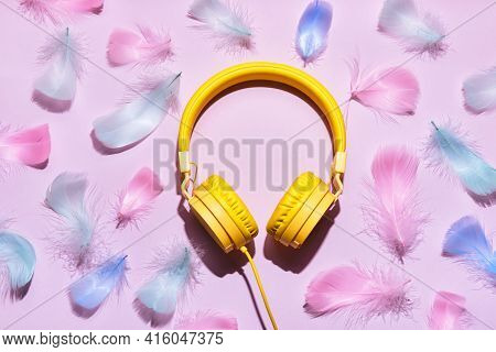 Yellow Headphones And Soft Feathers On Pink Background. Asmr Stress-relieving Sounds Concept, Flat L
