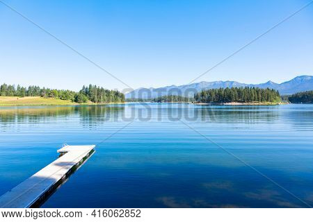 A calm beautiful scenic lake high in the Mountains of Montana called Echo Lake. A landscape photo that shows the beauty of Montana. Blue serene waters with a boat dock