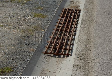 At The Edge Of The Road Is A Concrete Trough For Collecting Rainwater. For Cars And Cyclists To Cros