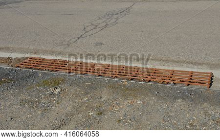 At The Edge Of The Road Is A Concrete Trough For Collecting Rainwater. For Cars And Cyclists To Cros