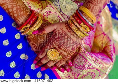Hindu Bengali Indian Bride Crossing Hands That Has Beautiful Mehndi Decoration And Expensive Gold Je