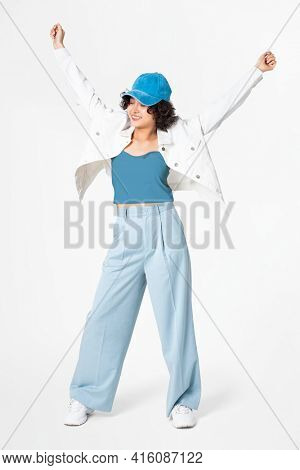 Happy woman posing in white jacket and blue outfit