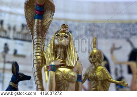 Still Life With Egyptian Figures Of Anubis, Cleopatra, Snake And The Goddess Eset. In The Background