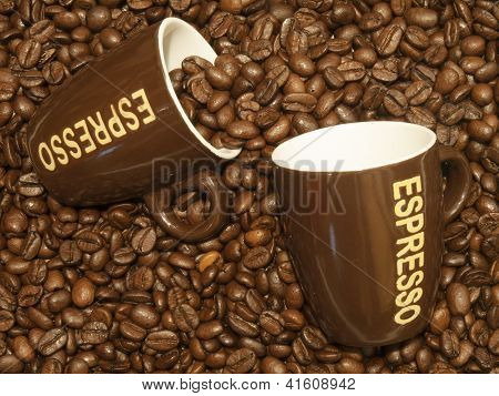 Kávová zrna jako pozadí s dvěma šálky na Espresso