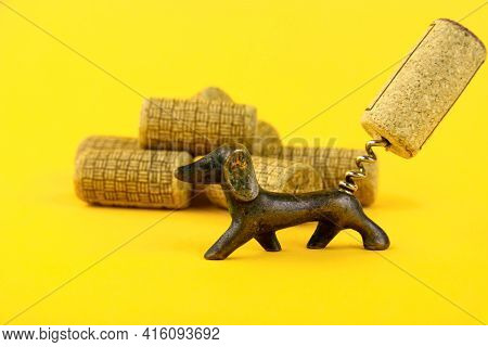 Close-up Of A Group Of Antique Dated Wine Corks And An Old Corkscrew, In The Form Of A Dachshund Dog