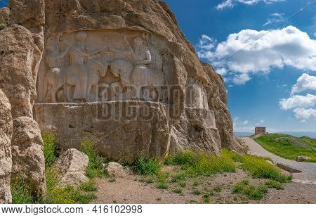 Murals Of Necropolis, King Burial Site Of Ancient Persia. King On His Horse Carved Into Sandstone Ro
