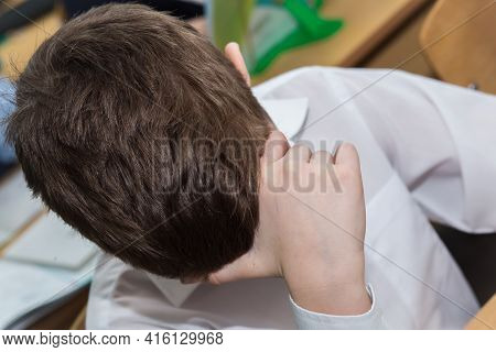 Close-up Of A Boys Hand Supporting His Head. A Student At School Sits At A Desk And Thinks Or Sleeps