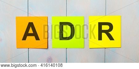 Three Colored Stickers With The Text Adr Alternative Dispute Resolution On A Light Blue Wooden Backg