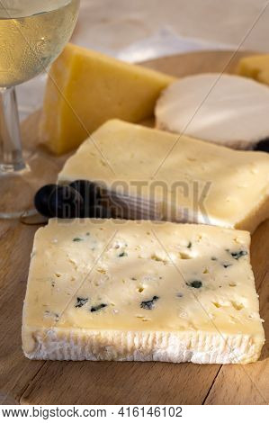 French Cheese Collection On Marble Board, Emmental, Carre De Aurillac, Petit Cantal Aop Jeune, Buche