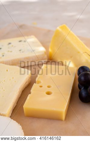 French Cheese Collection On Marble Board, Emmental, Carre De Aurillac, Petit Cantal Aop Jeune, Buche