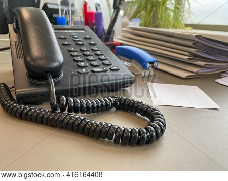 Black Wired Phone On The Desk Next To A Laptop In Office Desk