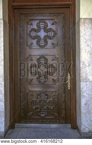 Brown Wooden Door Covered With Carved Decorative Patterns At The Entrance To The Belfry Of St. Sarki