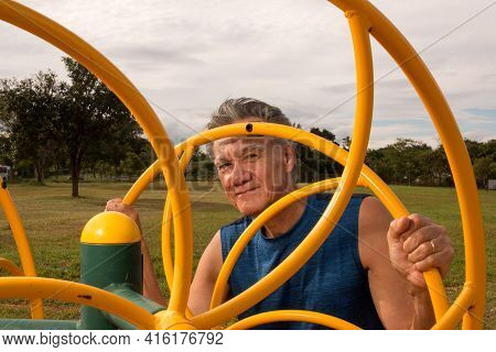 Senior Man Working Out At An Outdoor Fitness Park In Parque Das Garças, Brasilia